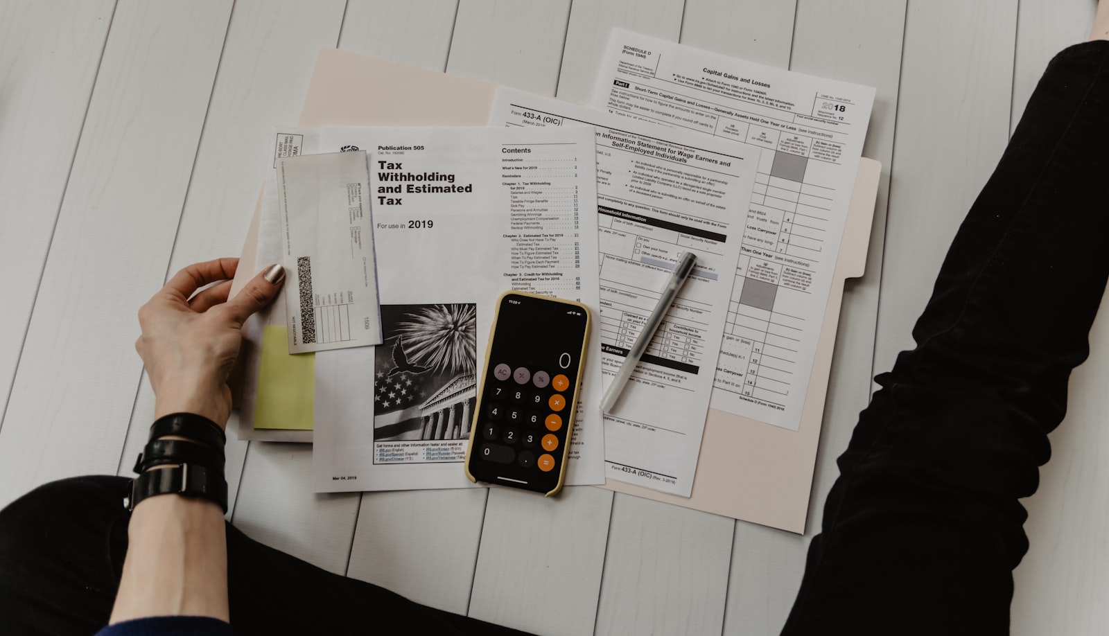 Tax paperwork, a pen, and a phone calculator on a desk